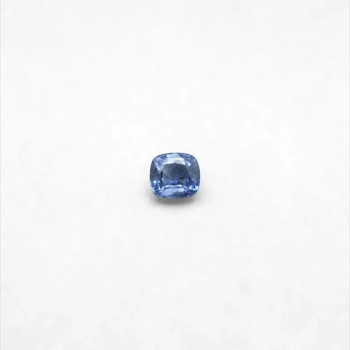 Faceted blue sapphire gemstone on white background