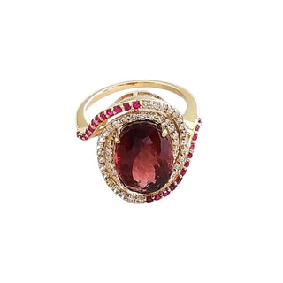 Elegant gold ring with oval red gemstone, diamond and ruby accents, luxury jewelry design