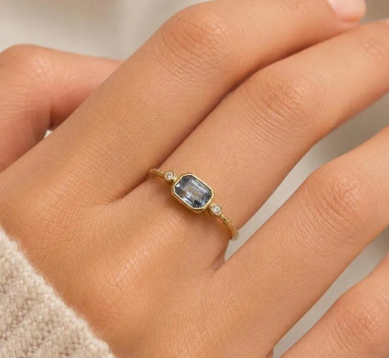 Elegant gold ring with blue gemstone and diamond accents, showcasing sophistication and timeless design.