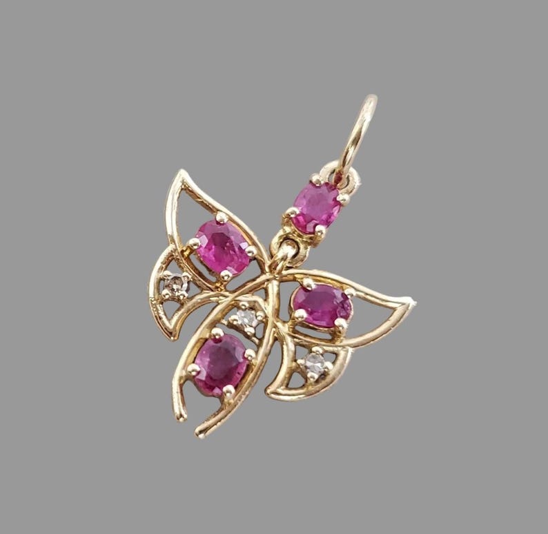 Gold butterfly charm set with red rubies, close-up