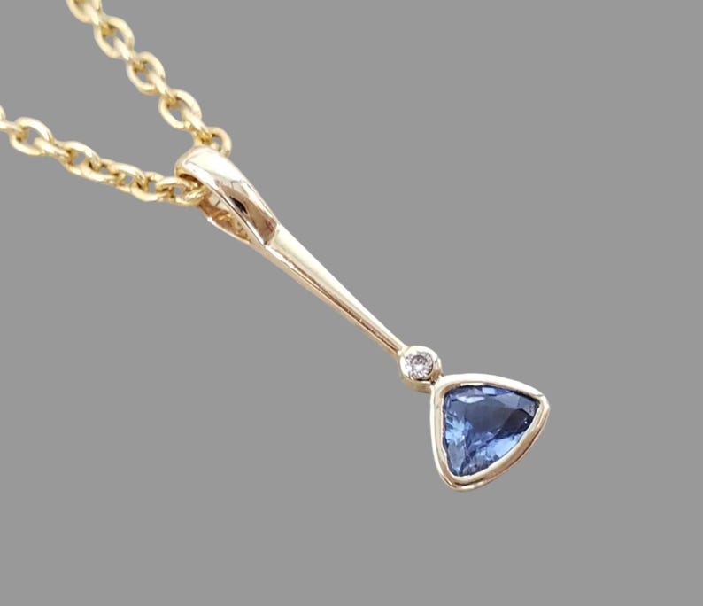 Trillion sapphire pendant with diamond accent, close-up
