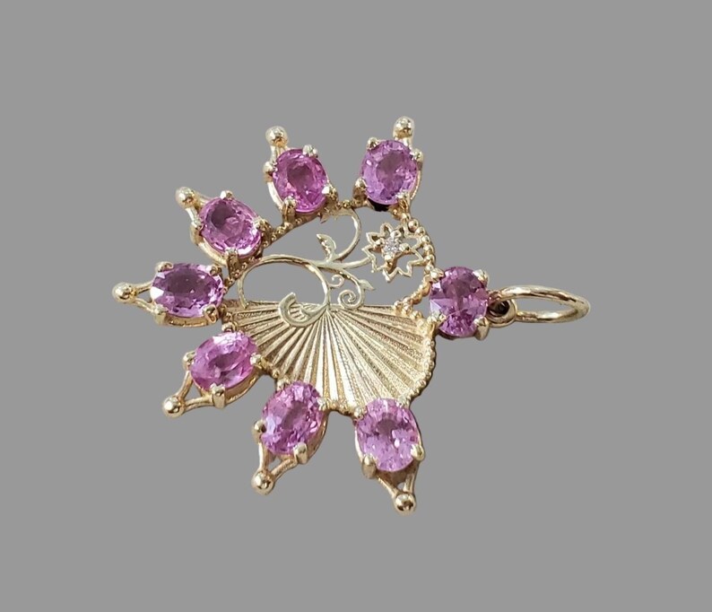 Handmade pink sapphire fan pendant shown in daylight
