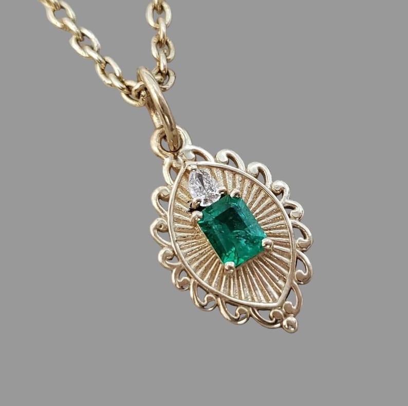 Emerald sunburst pendant with pear diamond in 14K gold
