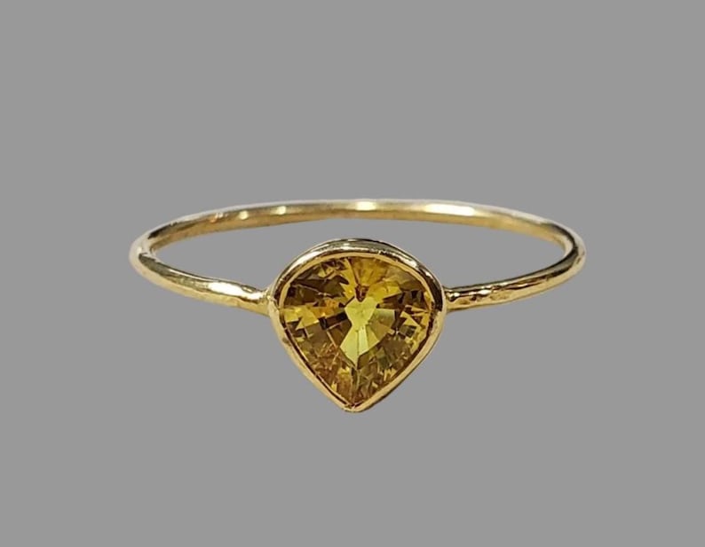 Yellow sapphire ring with heart shaped golden stone in 18K gold bezel