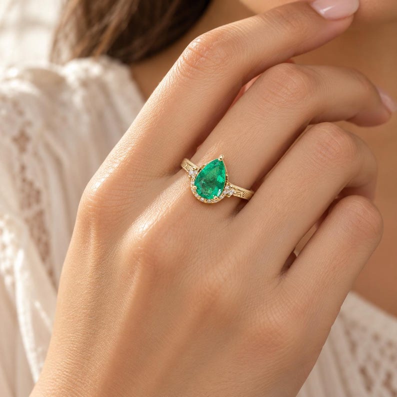 Handmade 14K gold emerald and diamond ring on the hand