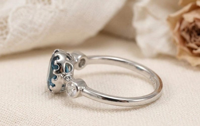 Oval blue topaz ring with two diamond accents