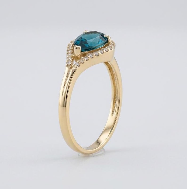 Pear-shaped blue spinel and diamond halo ring, 14K gold setting