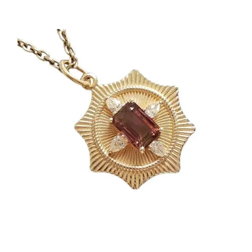 Elegant gold pendant with emerald-cut gemstone and diamond accents, radiating sophistication