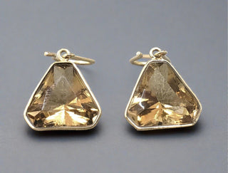 Close-up view of 14k Gold Birthstone Drop Earrings, showcasing stones set in gold.