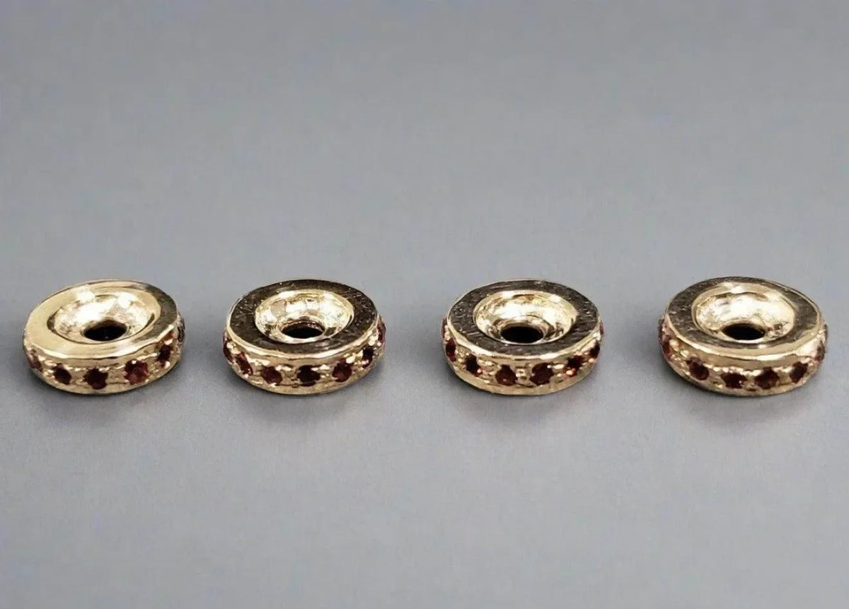 Gold-toned beads with red gemstone accents, ideal for elegant jewelry making and DIY accessories.