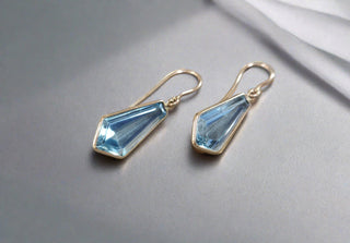 14k Gold Sky Blue Topaz Drop Earrings Showing on a grey background