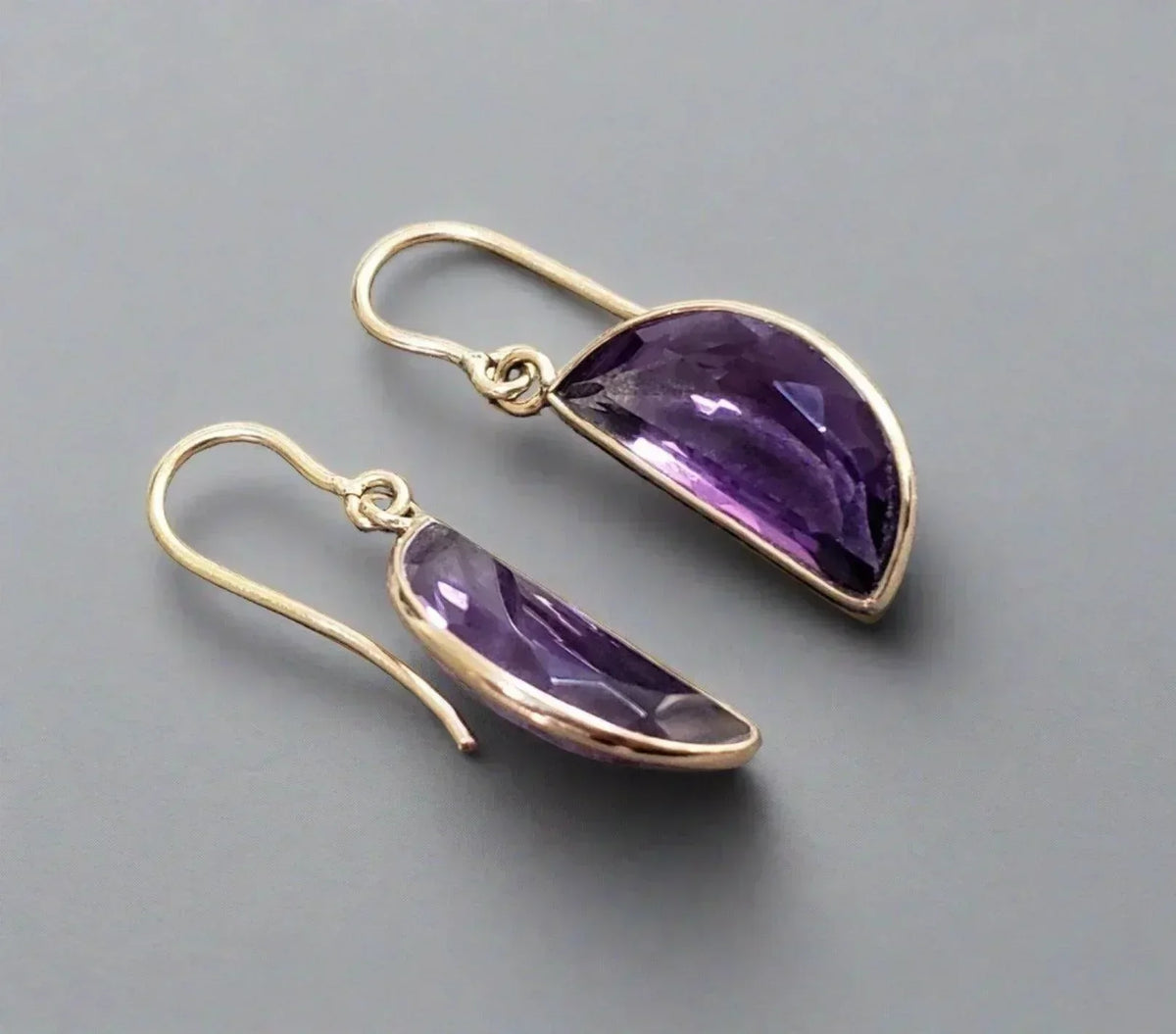 Elegant amethyst drop earrings with gold hooks, showcasing rich purple gemstones and sophisticated design.