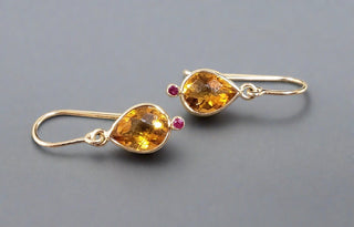 14k Gold Natural Pear Citrine and Ruby Drop Earrings showing on a grey background