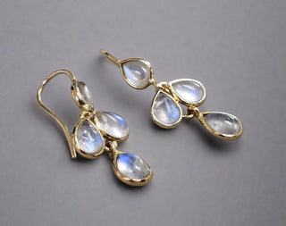 14k Gold Rainbow moonstone Gold Earring made with natural stones in elegant design showing on a grey background