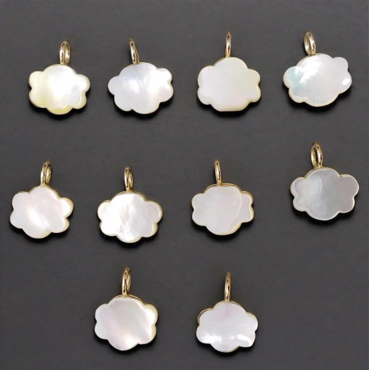 Elegant cloud-shaped mother-of-pearl pendants with gold settings, perfect for delicate jewelry designs