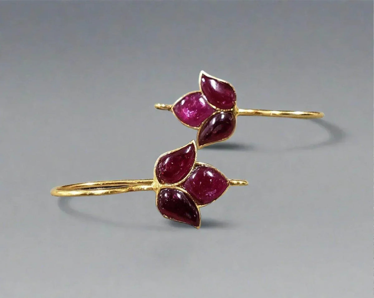 Elegant gold bangle with vibrant ruby gemstones, perfect for luxury jewelry lovers