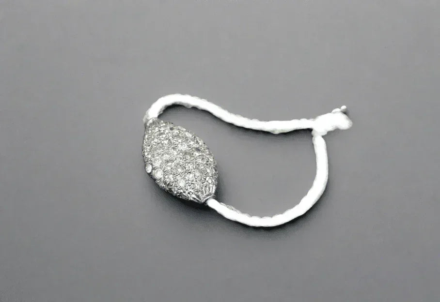 Elegant diamond-encrusted pendant on a white cord, showcasing sophistication and luxury.