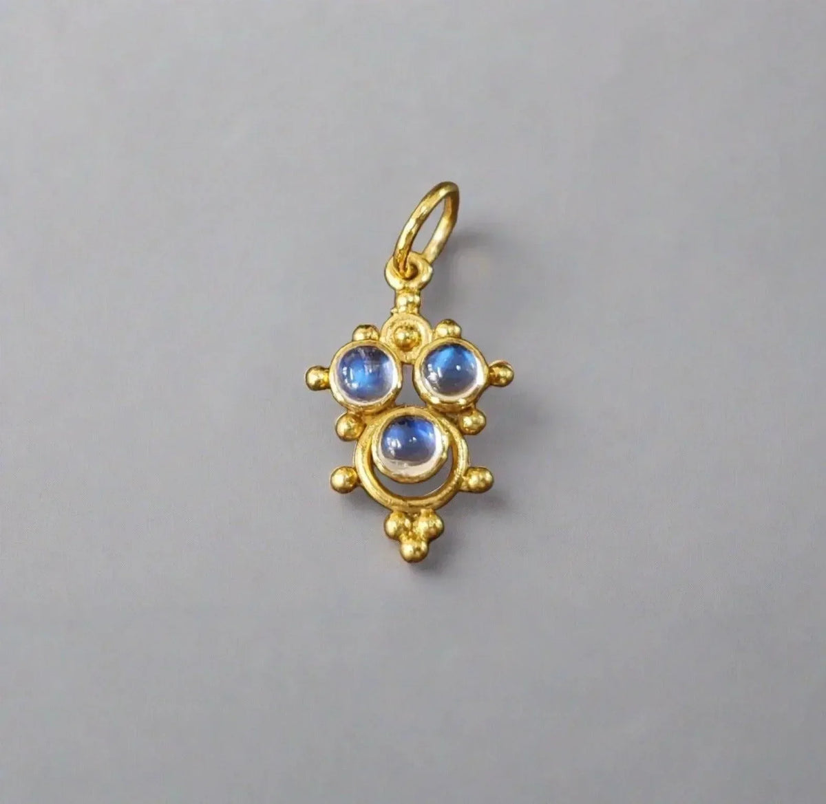Gold pendant with three blue gemstones, elegant jewelry accessory
