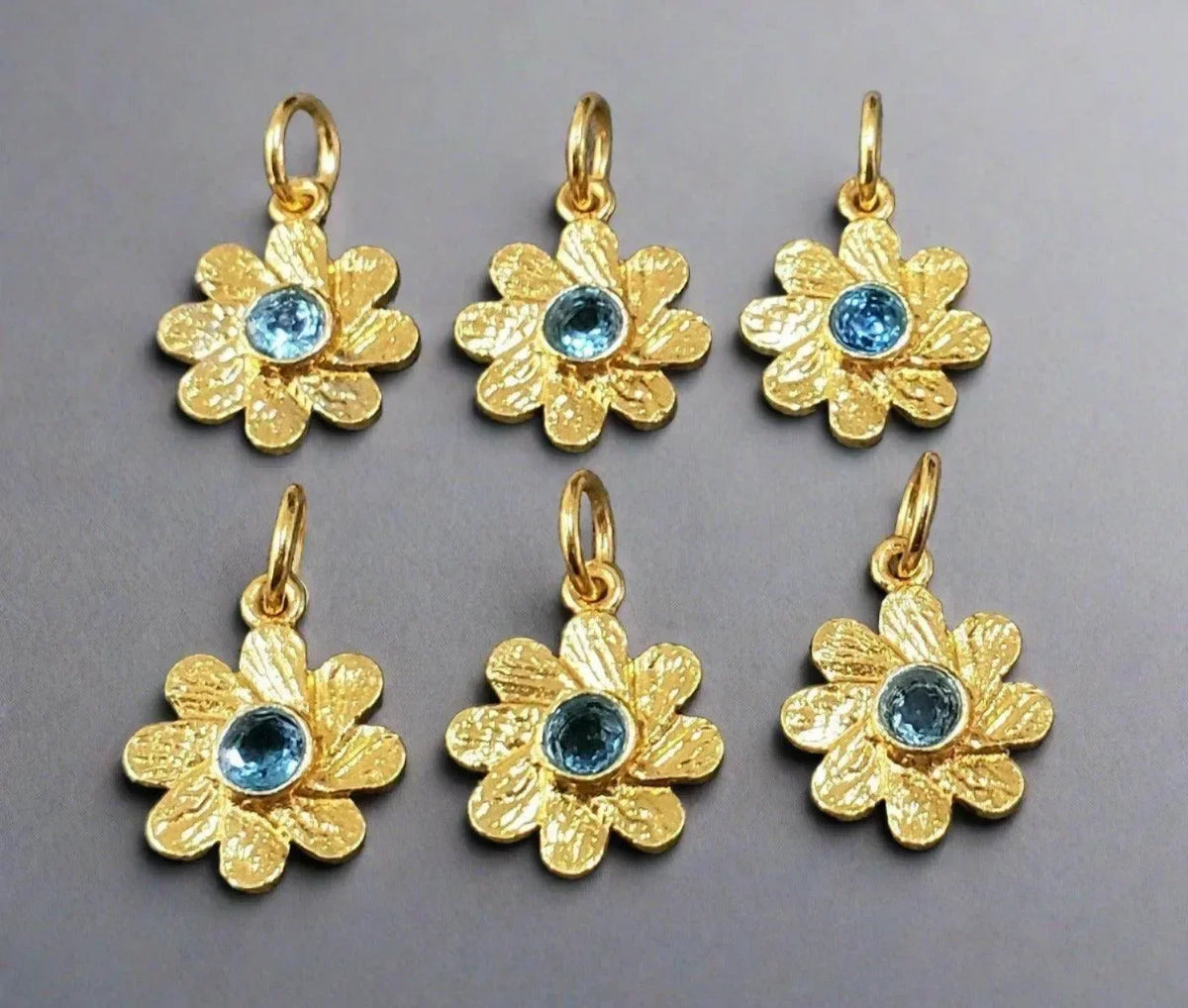 Gold flower charms with blue gemstone centers, elegant jewelry accessories