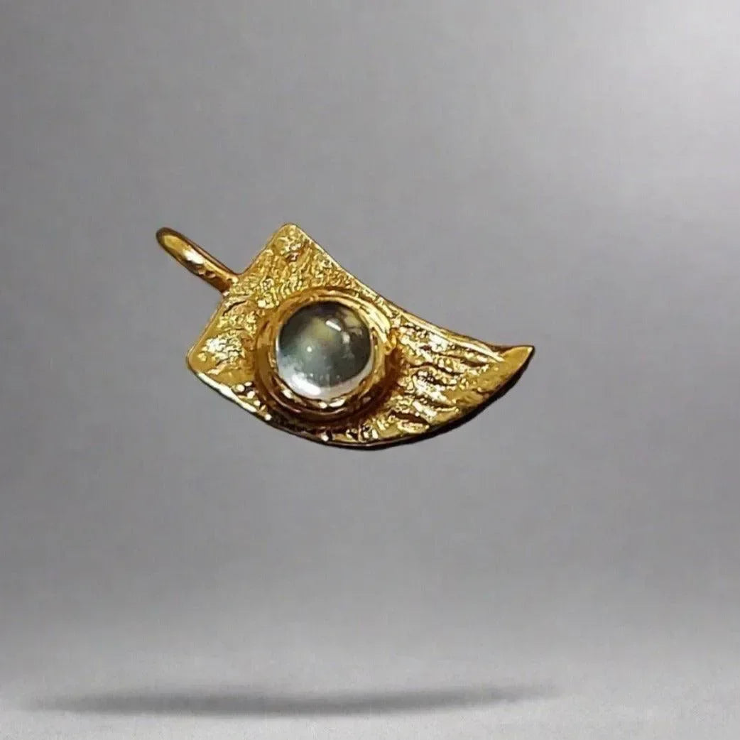 Gold pendant with textured wing design and central gemstone, elegant jewelry accessory