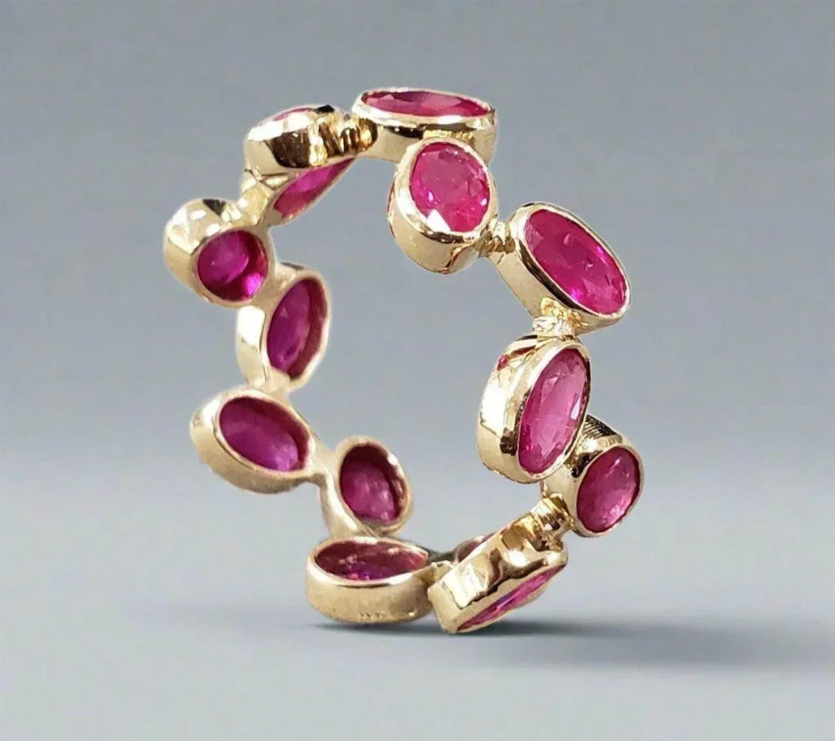 Elegant gold ring with vibrant pink gemstones, perfect for luxury jewelry lovers