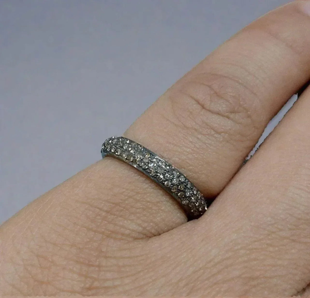 Elegant diamond eternity band ring on finger, sparkling gold & diamond jewelry for sophisticated style