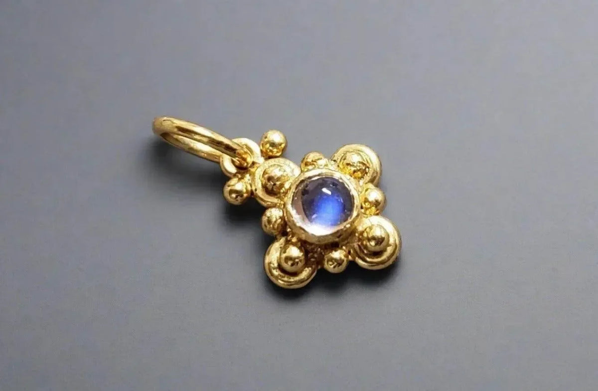 Gold pendant with blue gemstone, elegant floral design, luxury jewelry accessory