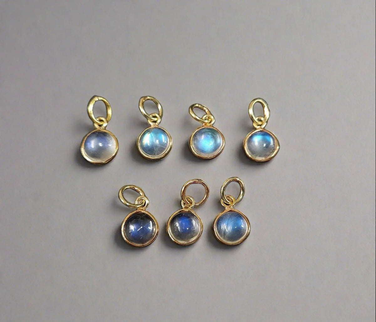Gold-plated moonstone charms with blue adularescence, ideal for elegant jewelry making