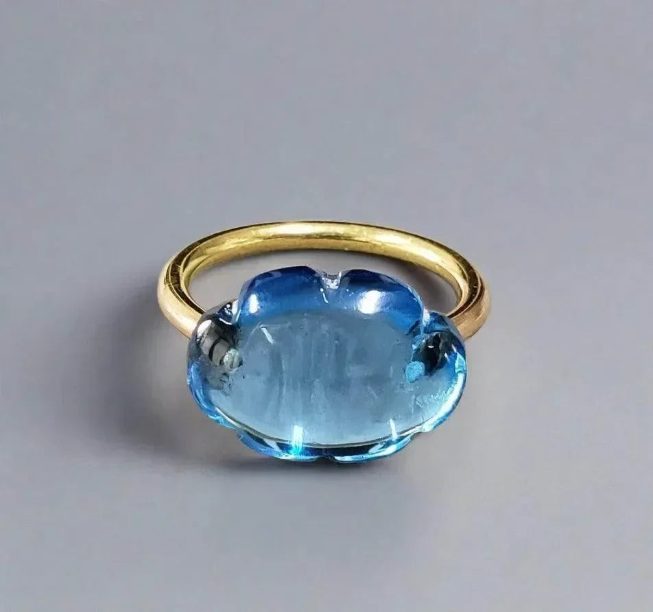 Elegant gold ring with large blue gemstone, sophisticated jewelry accessory