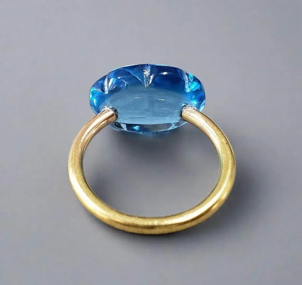Elegant gold ring with large blue gemstone, sophisticated jewelry accessory
