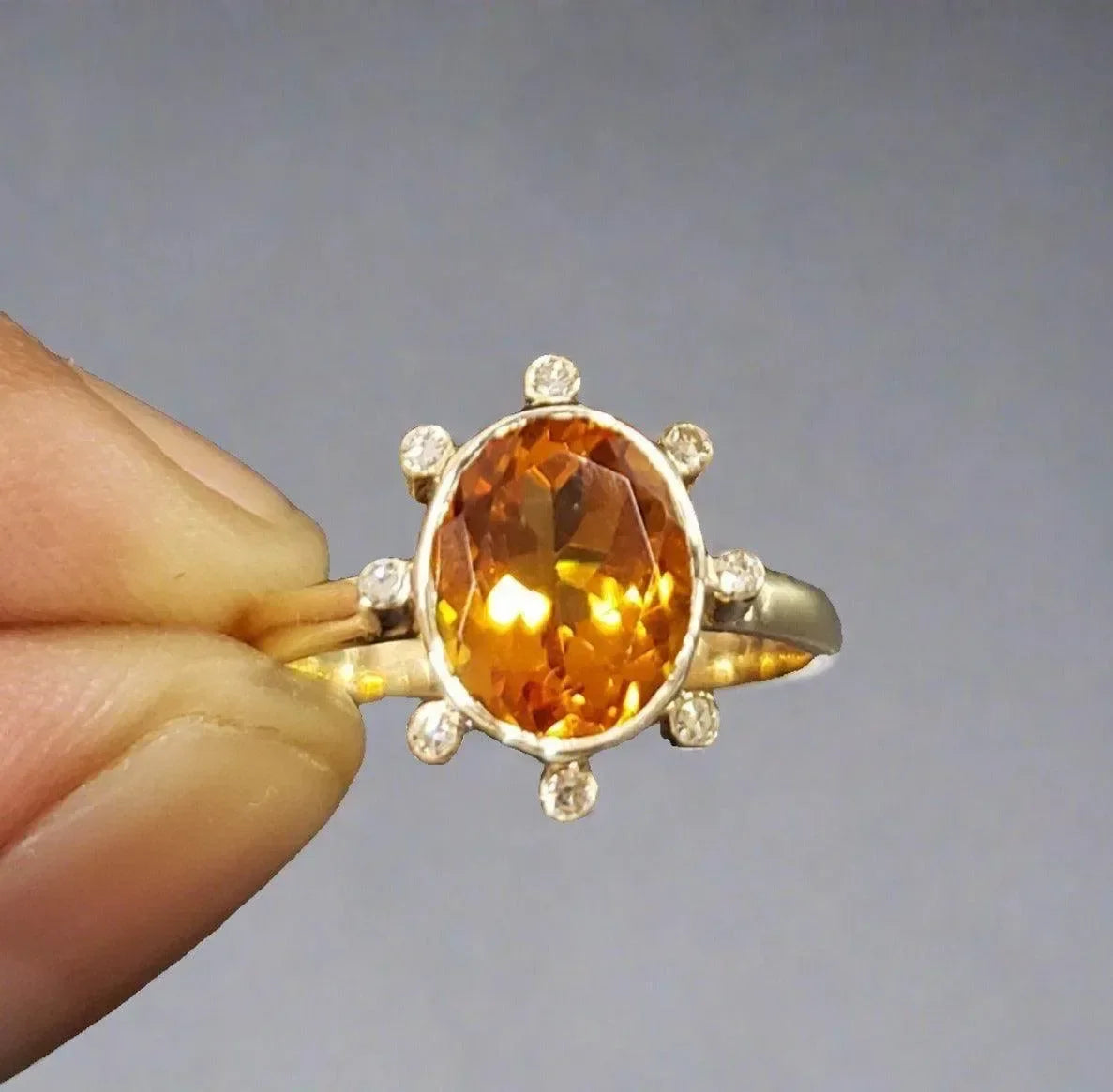 Elegant gold ring with oval citrine gemstone and diamond accents, perfect for sophisticated jewelry lovers.