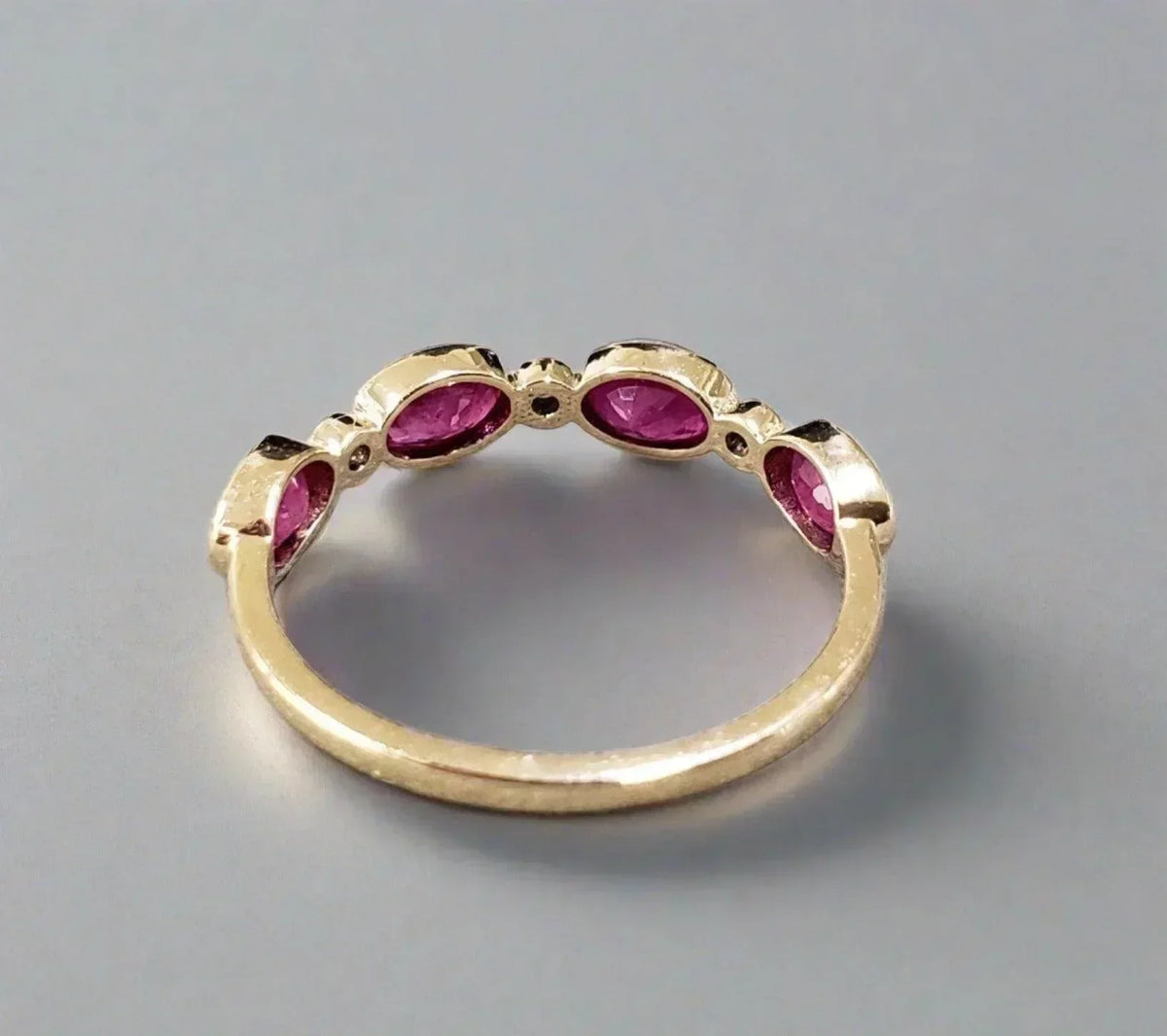 Elegant gold ring with oval pink gemstones, perfect for luxury jewelry lovers