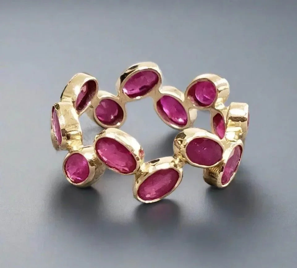 Elegant gold ring with vibrant oval rubies, luxury jewelry for sophisticated style